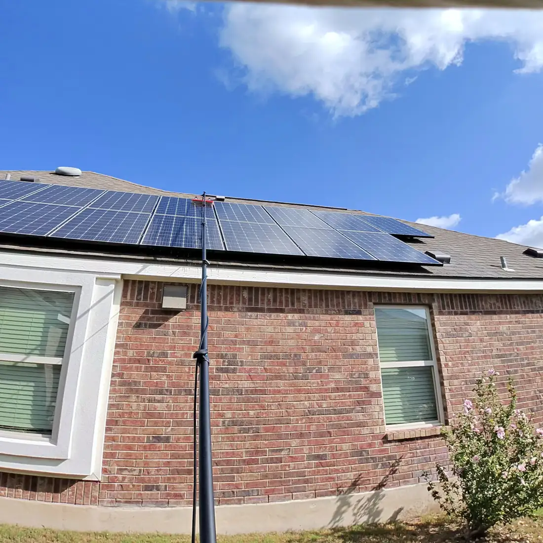 Water-fed pole reaching a rooftop solar array from ground level