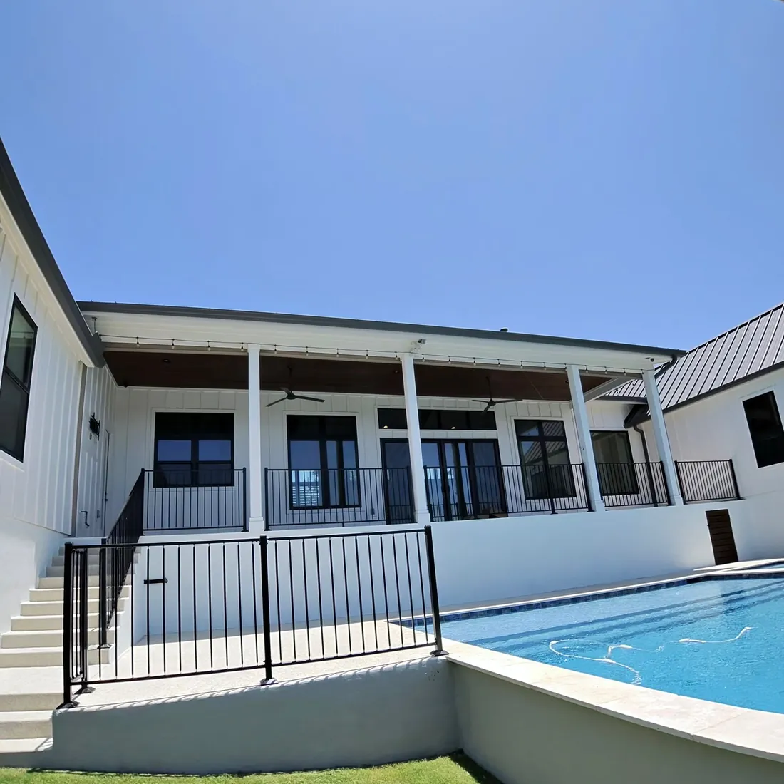 Covered porch and pool at a white modern farmhouse