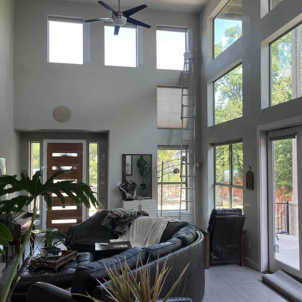 Open living room under a vaulted ceiling with full height glass on two sides