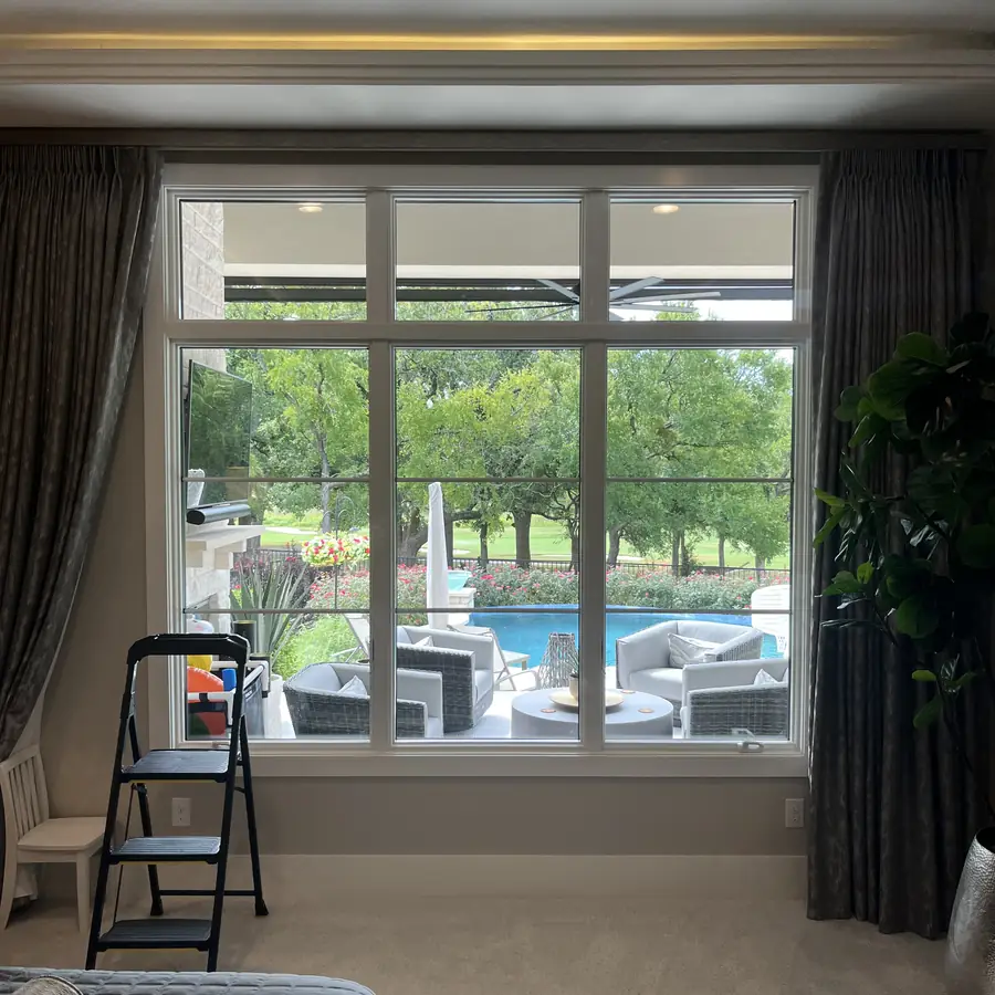 Bedroom window looking out over the pool terrace, step ladder set up for the interior clean