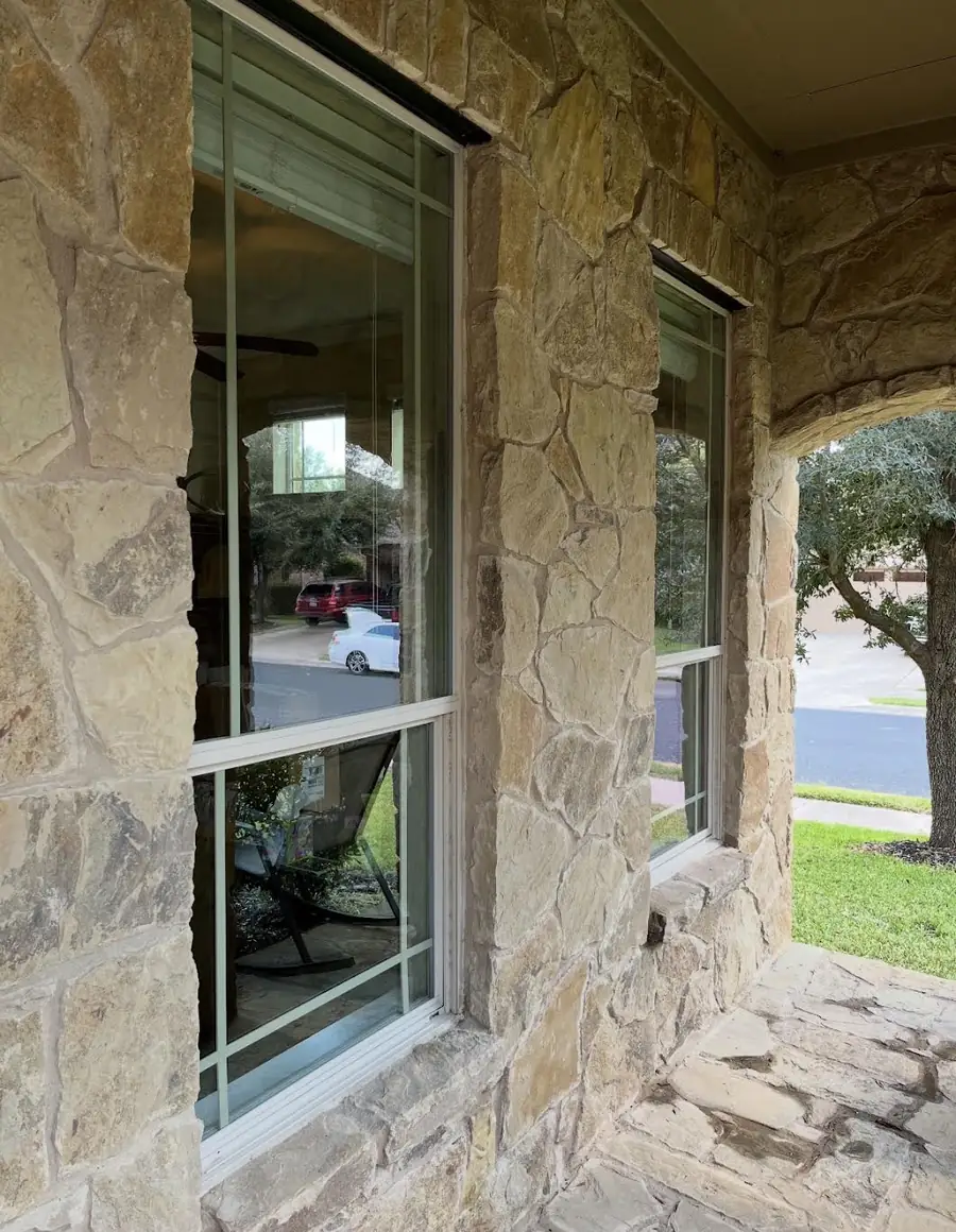 The same two windows after hard water removal, with the street, parked cars and the room inside clearly visible