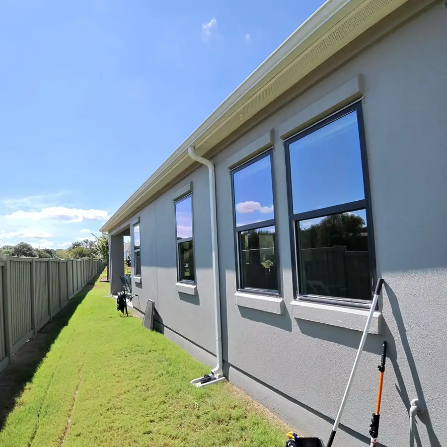 Long run of windows down the side of a Leander home with the hose laid out along the lawn